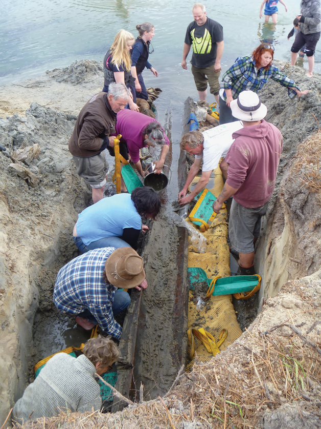 Volunteers lend a hand to extract a prehistoric tōtara waka from a sand dune  at Papanui Inlet in October. It is the second-oldest waka ever found in Aotearoa.