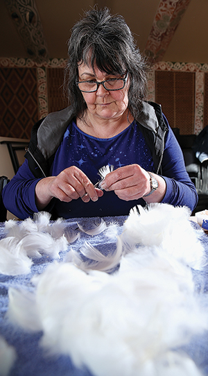 Barbara Metzger preparing feathers for weaving.